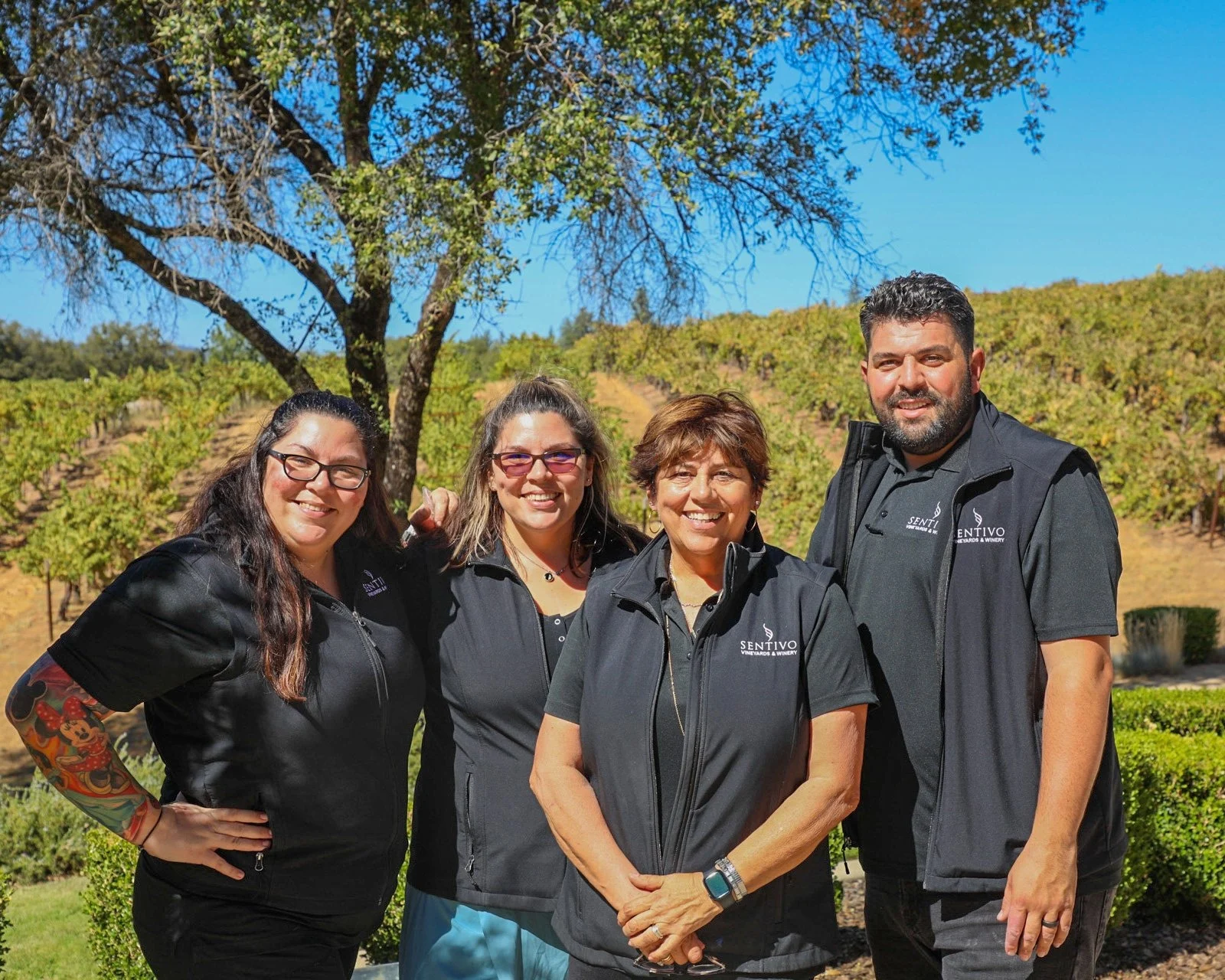 The Pierson family, owners of Sentivo Vineyards & Winery, posing by vines.