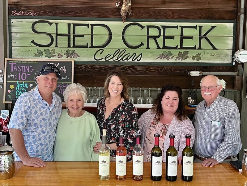 Shed Creek Cellars winery team posing in front of their tasting bar.