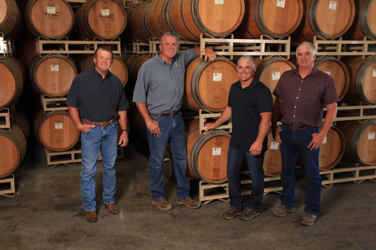 Lanza family, of Wooden Valley Winery, standing in front of wine barrels at Suisun Valley tasting room.